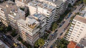 A high-rise residential building with multiple balconies, a parking area, and a street view. - Jacuzzi Lux penthouse P Faliro (Paleo Faliro)