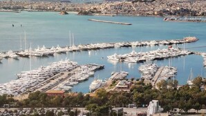 A marina with numerous yachts docked, surrounded by residential buildings with balconies. - Jacuzzi Lux penthouse P Faliro (Paleo Faliro)