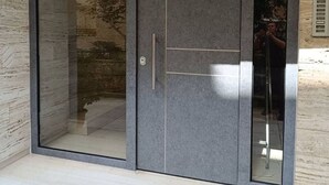 Uma porta de correr de vidro moderna, com puxador metálico e painel de vidro.