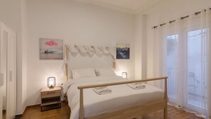 A neatly arranged bedroom with a bed, bedside tables, and artwork on the walls.