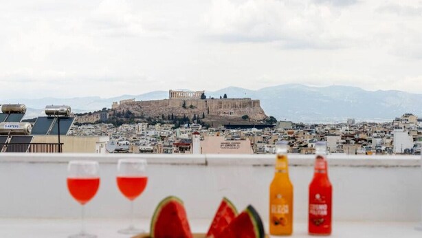 A rooftop terrace with a view of a historic fortress and cityscape.
