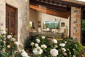 A rustic interior with a stone wall, wooden door, and a cozy seating area with a sofa and table. - My Rental Homes - Villa Collombroso with pool, large terrace and pergola (Porano)