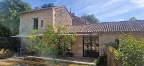 A stone building with a tiled roof, a small window, and a door. - Characterful Country House – Château-Fromage (Bignoux), Sleeps 4 (Bignoux)