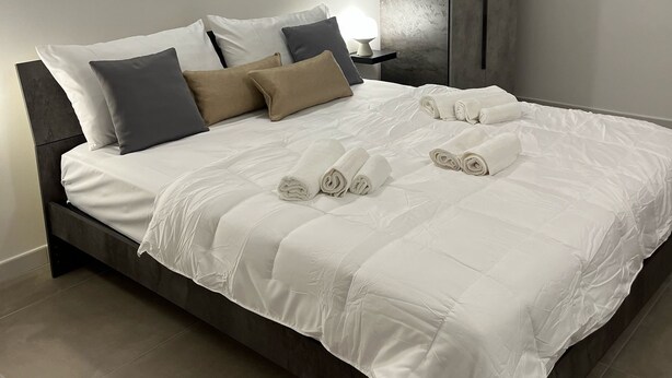 Une chambre moderne avec un grand lit, une armoire et un appareil de climatisation.