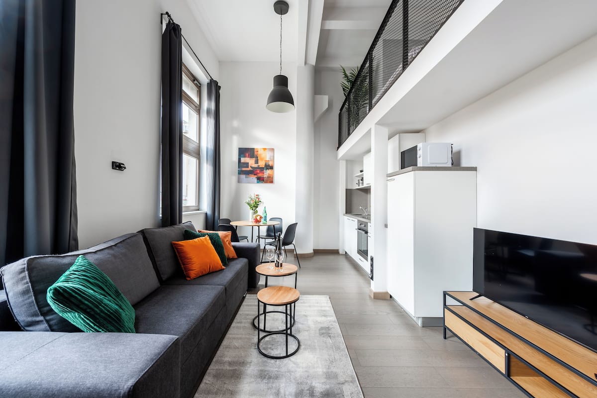 Een moderne woonkamer met een grijze bank, een salontafel en een televisie.