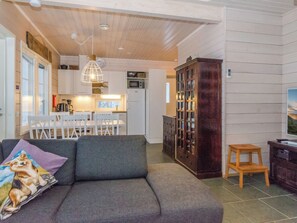 Una sala de estar acogedora con un sofá gris, un aparador de madera y un taburete pequeño de madera.