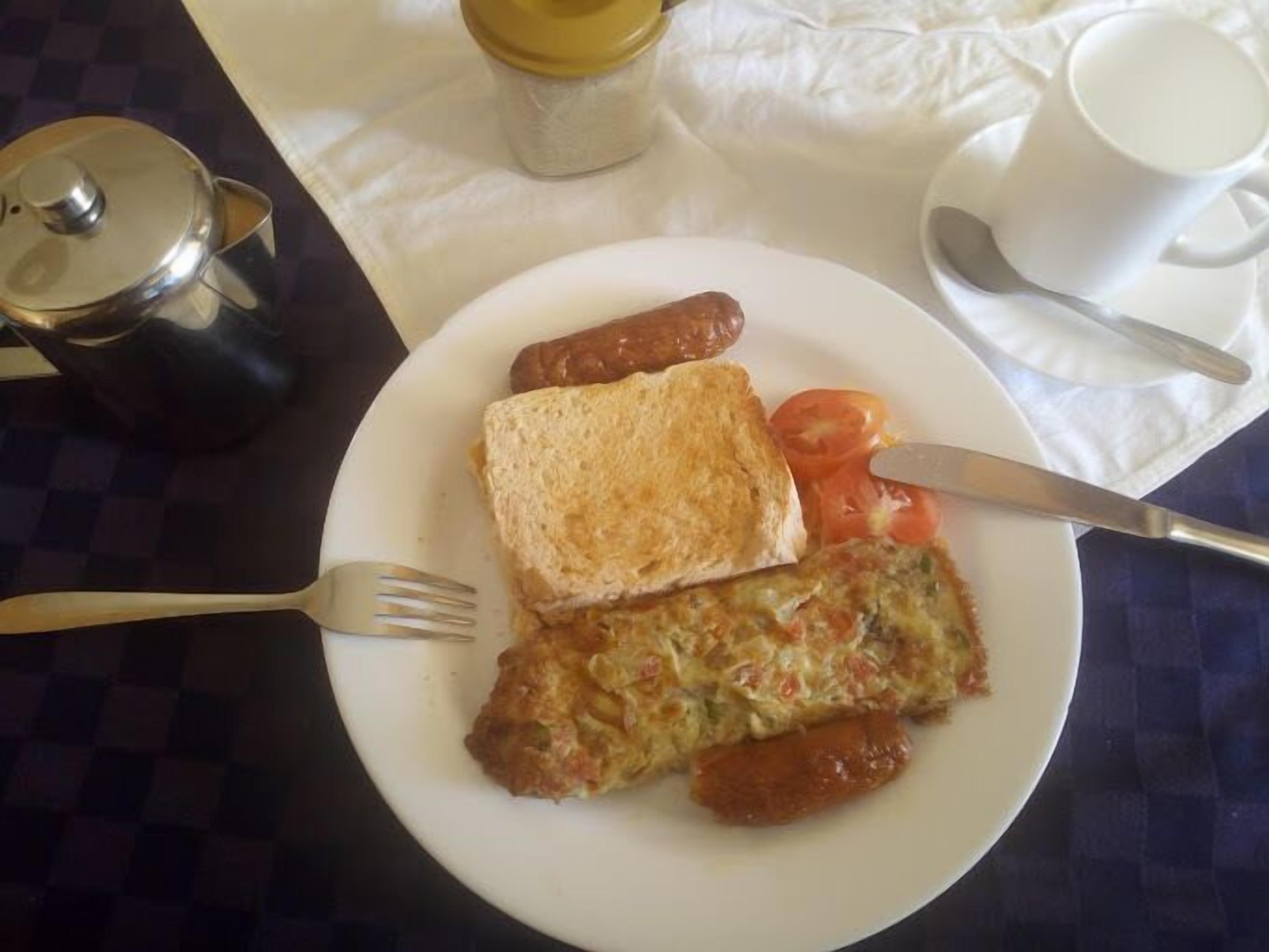 Un plato con tostadas, salchichas y un huevo frito.