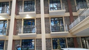 A multi-story building with balconies, large windows, and a stone facade. - Hotel Staridge Limited (Homa Bay)