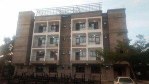 A multi-story building with a symmetrical facade, featuring balconies on each floor. - Hotel Staridge Limited (Homa Bay)