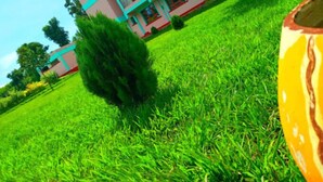 A multi-story building with balconies, surrounded by a well-maintained grassy area. - Hotel Staridge Limited (Homa Bay)