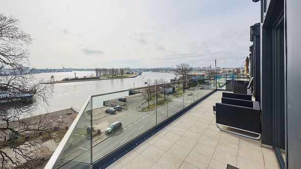 A balcony with a view of a river and cityscape. - APARTAMENTY ŚWINOUJŚCIE - NOWA FLOTYLLA (Swinoujscie)