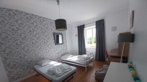 A room with two single beds, a desk, a chair, a hanging lamp, and a window with curtains. - Beaujolais house with charm, pool, fireplace (Gleizé)