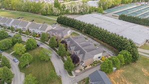 A residential area with detached houses, a large parking lot, and a commercial building.