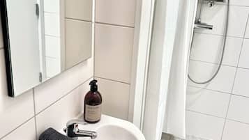 Comfort dubbelrum - utsikt mot trädgården (delat badrum) | Baño | Ducha, toallas, jabón y champú