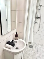 Comfort dubbelrum - utsikt mot trädgården (delat badrum) | Bathroom | Shower, towels, soap, shampoo