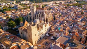 An aerial view of a historic city with a prominent cathedral featuring a tall tower and a large square in front. - Apartment Paradis Gruissan (Gruissan)
