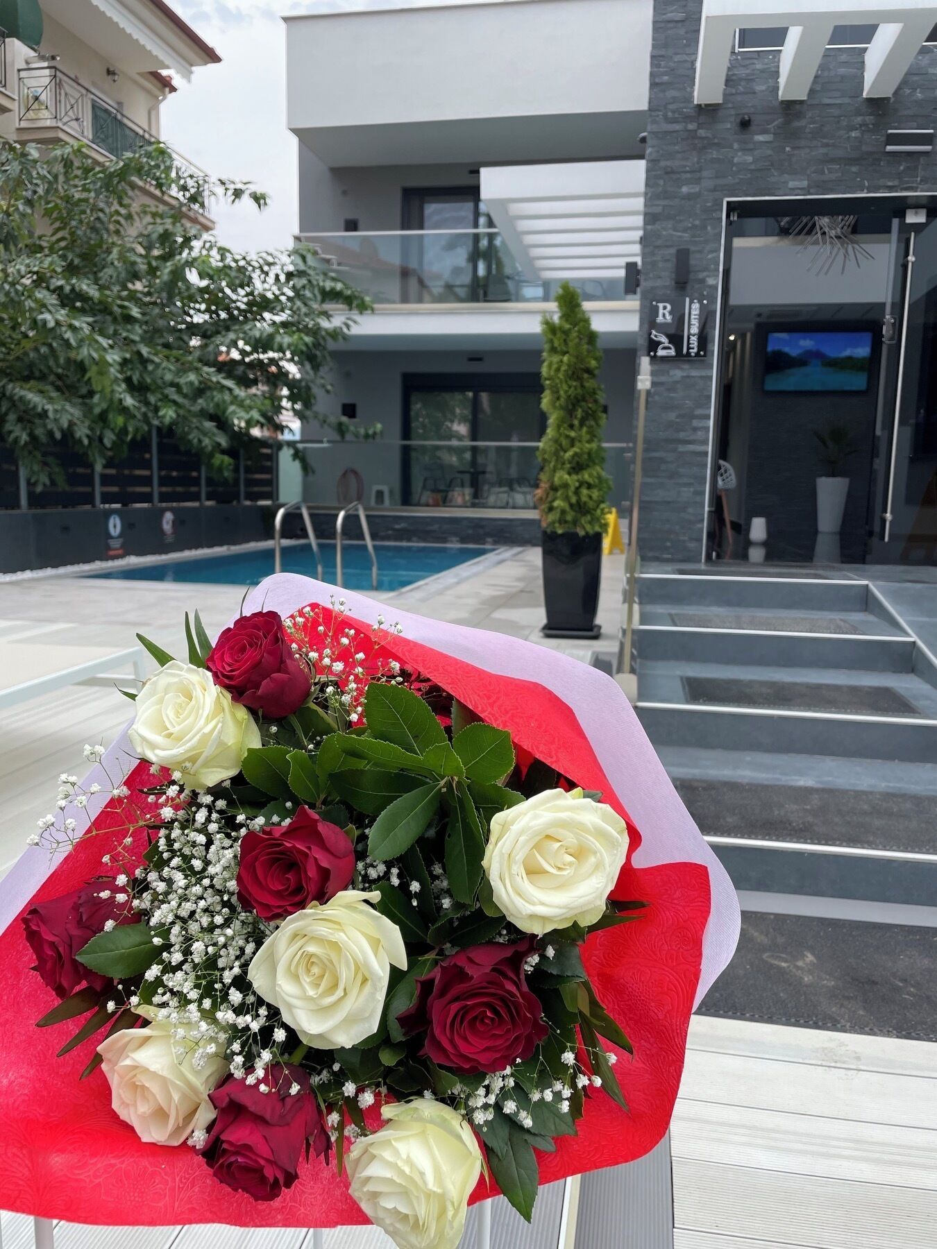 A bouquet of roses on a white chair by a poolside.