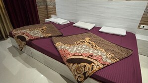A room with a bed, a headboard, and patterned walls. - Hotel Shri Radha Niwas (Katra)