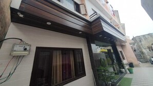 A modern two-story building with a flat roof, large windows, and a balcony. - Hotel Shri Radha Niwas (Katra)