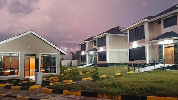 A modern residential building with multiple units, each featuring large windows and a flat roof. - Key Villa (Homa Bay)