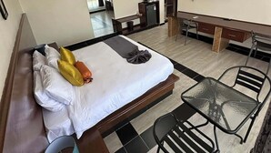 A hotel room with a bed, a desk, a chair, a TV, and a bathroom. - Key Villa (Homa Bay)