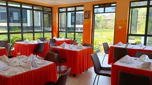 A conference room with tables set for dining, large windows, and a view of the outdoors. - Key Villa (Homa Bay)
