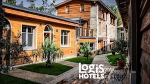 A wooden building with a stone staircase and a paved walkway. - Nature Cathare (Léran)