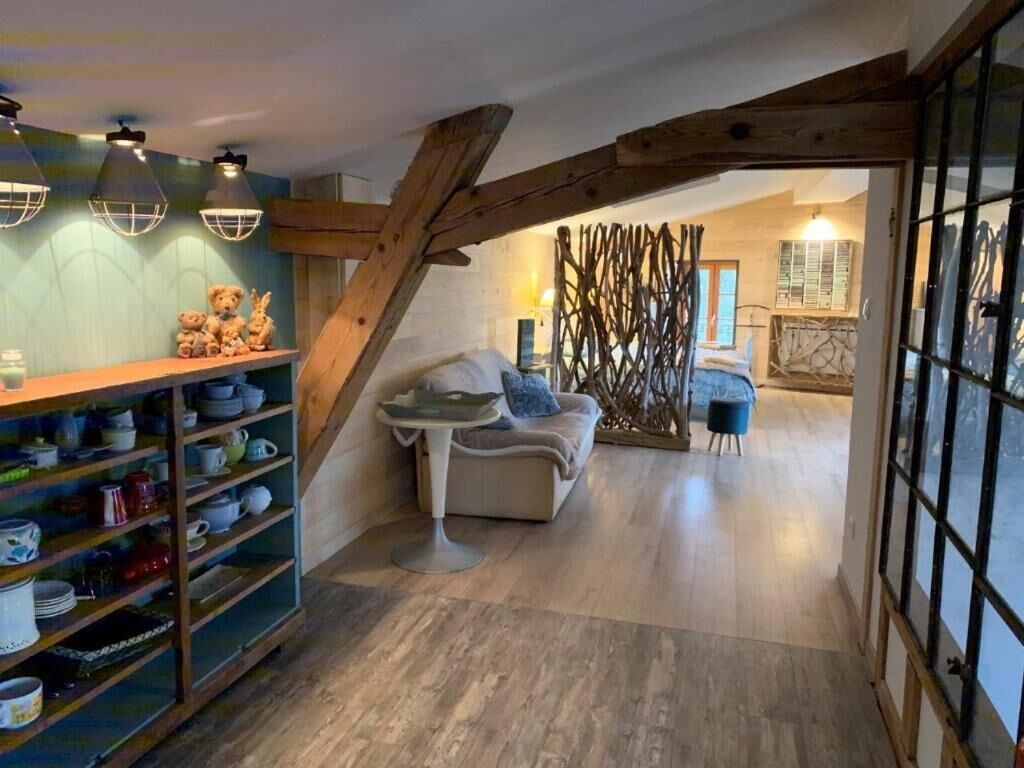 A cozy interior with a wooden staircase, a sofa, and a dining area with a table and chairs.