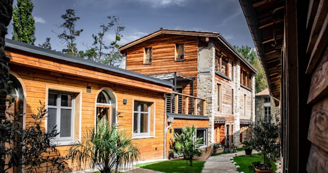 Un edificio de madera con escalones de piedra y un sendero pavimentado.