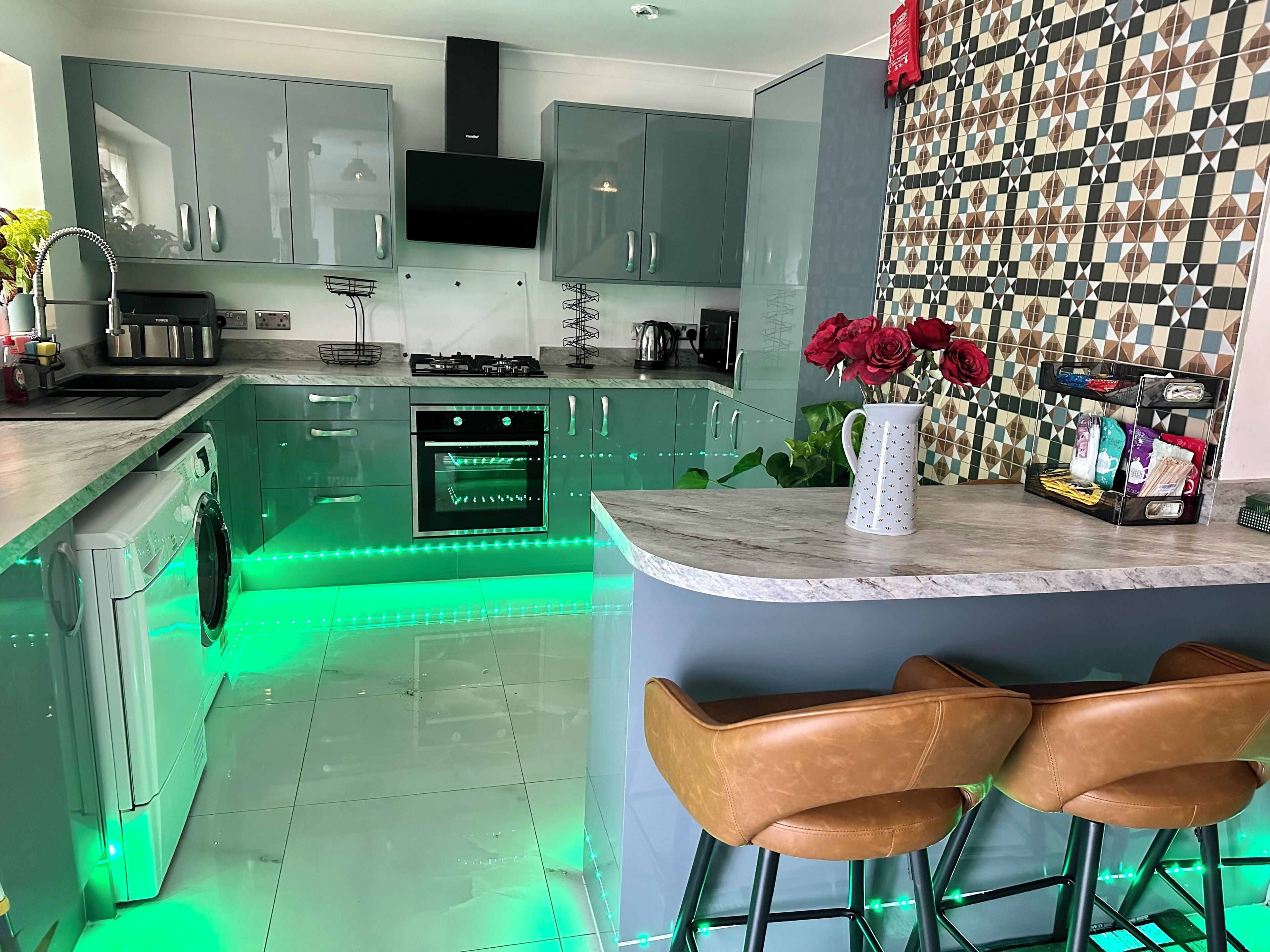 A modern kitchen with a built-in oven, a coffee machine, and a sink.