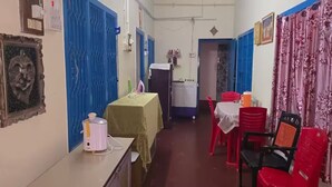 A narrow corridor with a table and chairs, a radiator, and a water dispenser. - 2BHK Homestay @ Gundicha Temple Best 4 Ratha Yatra (Puri)