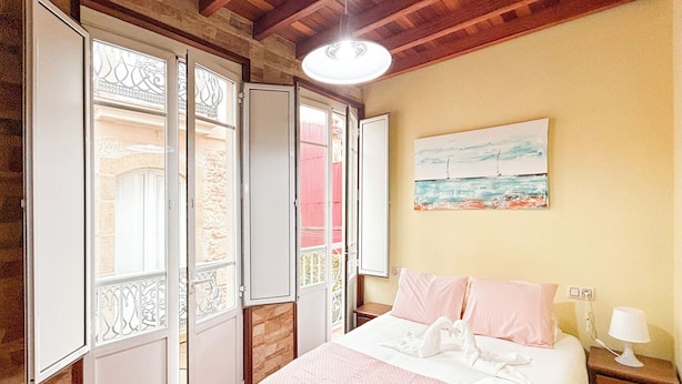 Un dormitorio con una cama, una mesita de noche, una lámpara y un cuadro en la pared.