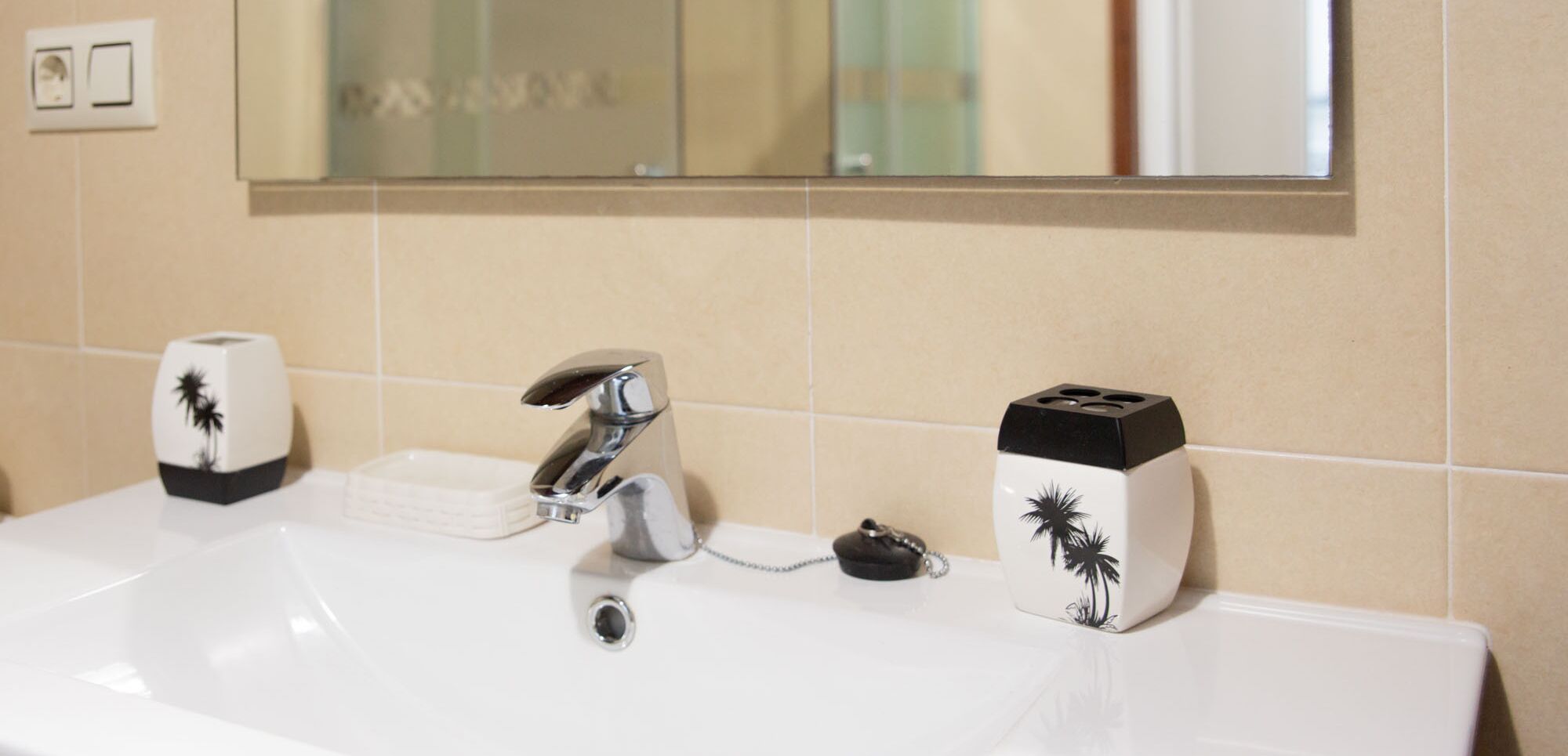 A bathroom sink with a modern faucet, a soap dispenser, and a toothbrush holder.