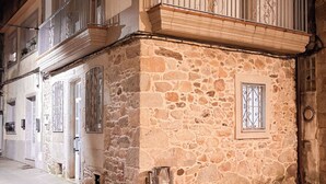 Un edificio de varios pisos con base de piedra y sección superior blanca.