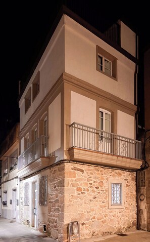 A multi-story building with a stone base and a white upper section.