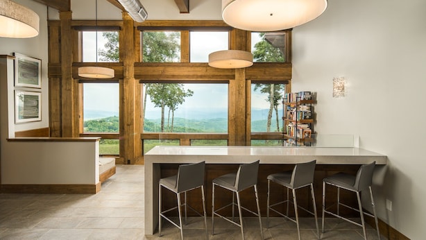 A modern kitchen with a large island, bar stools, and a view of the outdoors. - 4BR Luxury Home, Hot Tub, Game Room, Walk to Pool & Grill (Boone)