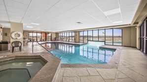 An indoor swimming pool with a view of a bridge and mountains. - Harbour Place 206 (Orange Beach)