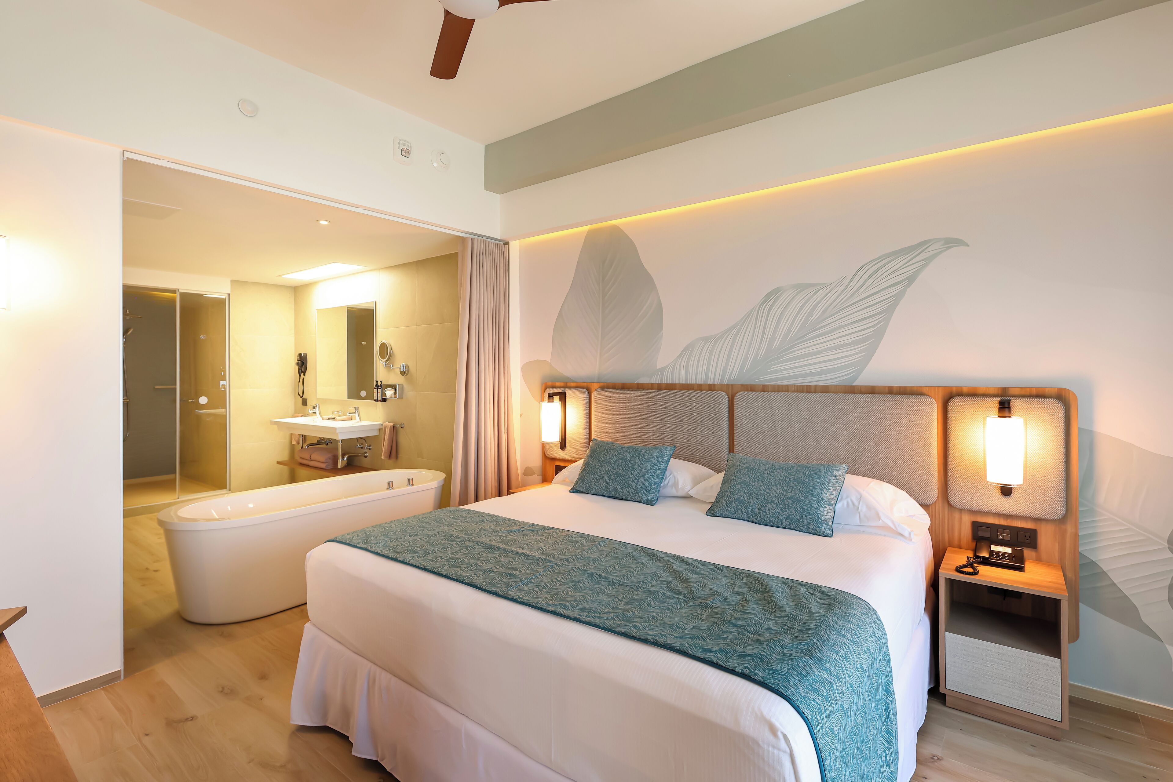 Ein modernes Hotelzimmer mit einem großen Bett, einem separaten Badezimmer und einer Duschkabine.