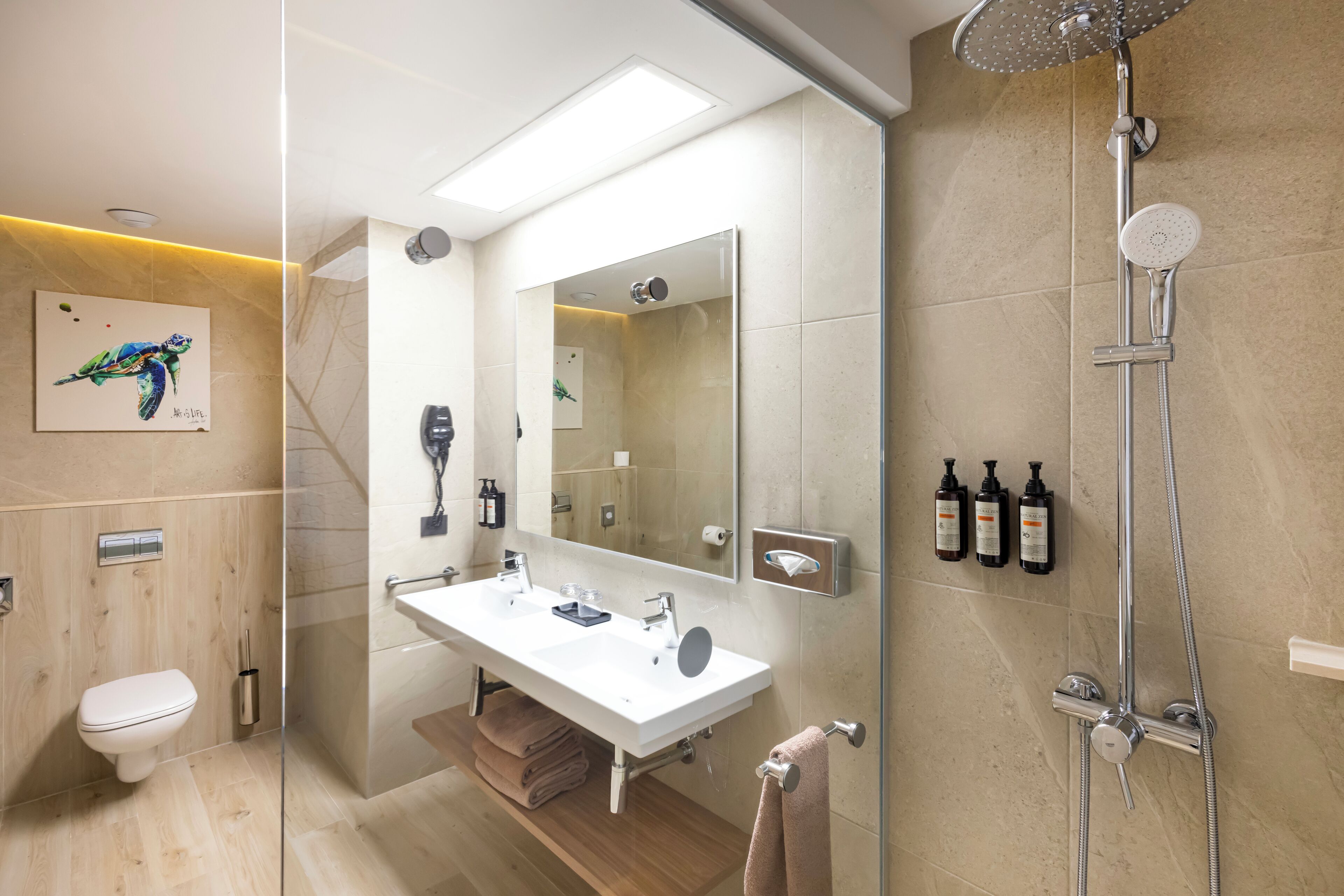 A modern bathroom with a glass shower enclosure, a large mirror, and a white sink.