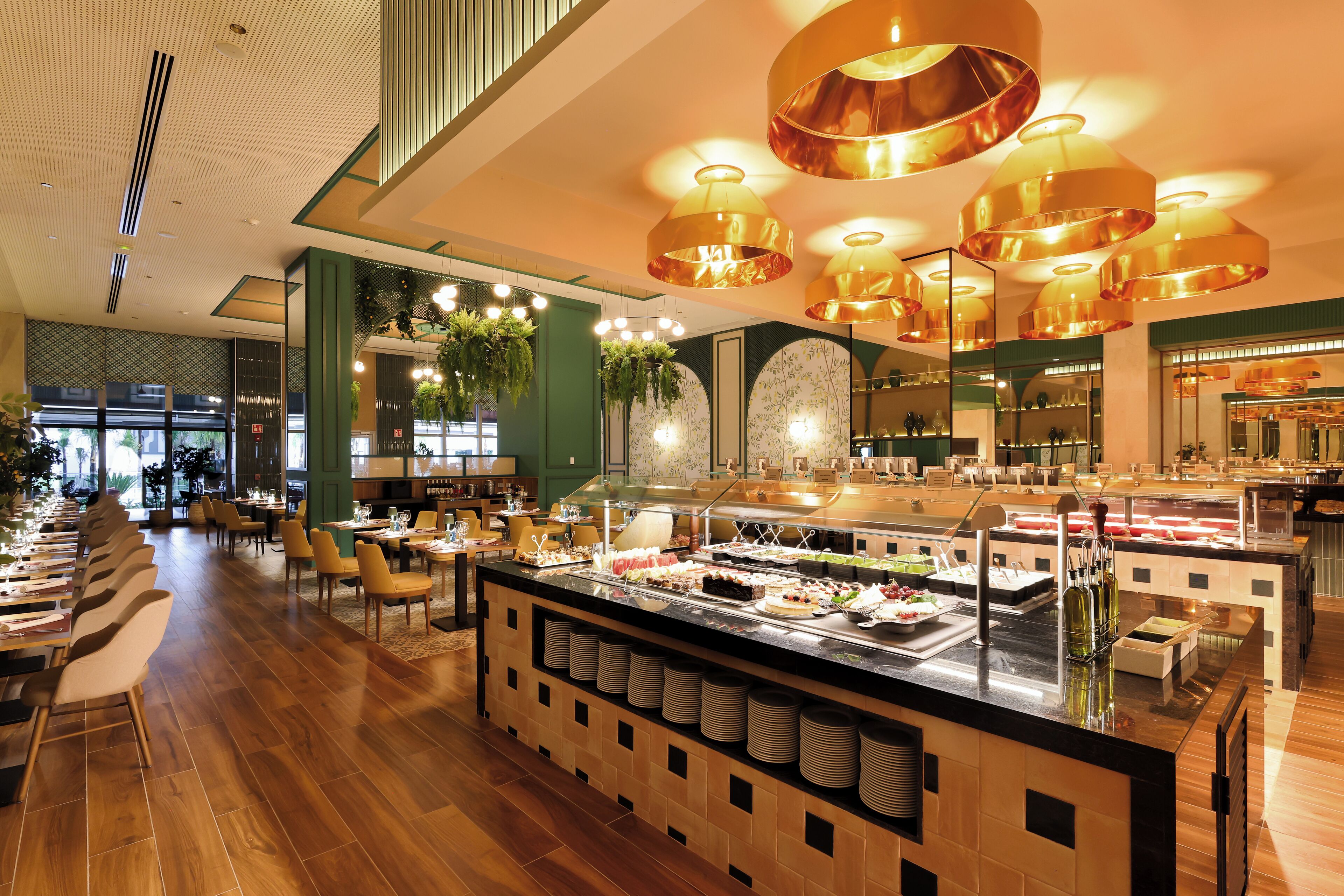 Een buffetgedeelte met diverse voedselopties, een centraal buffet en een zithoek met tafels en stoelen.