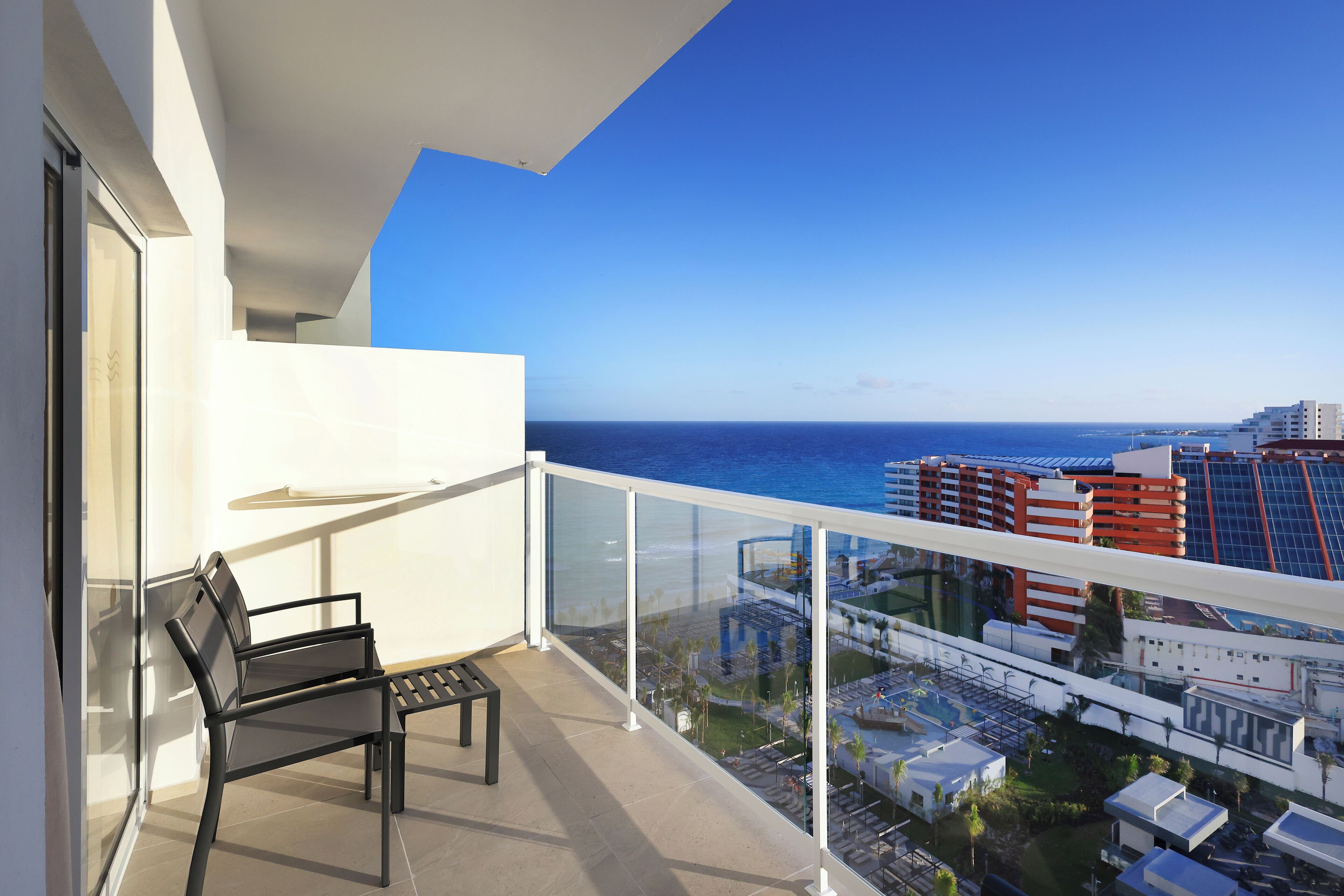 Un balcon avec vue sur l’océan et le paysage urbain.