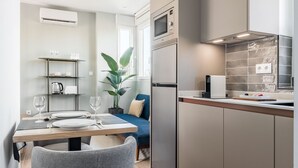 Eine moderne Küche mit Essbereich, ausgestattet mit einem Backofen, einer Mikrowelle und einer Kaffeemaschine.