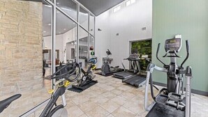 A gym with treadmills, elliptical machines, and a stationary bike.