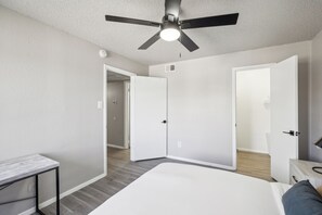2 habitaciones, escritorio y tabla de planchar con plancha