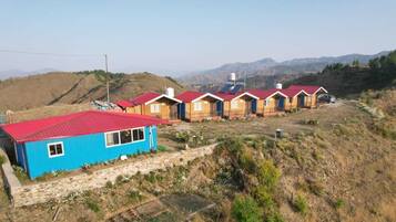 Cabins nestled among rolling hills and distant mountains.