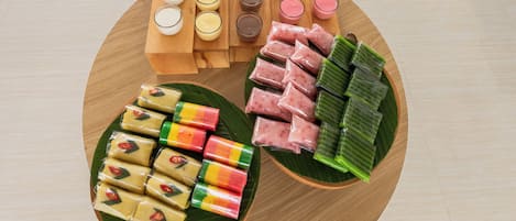 A variety of food items arranged on a wooden table with a reflective floor.