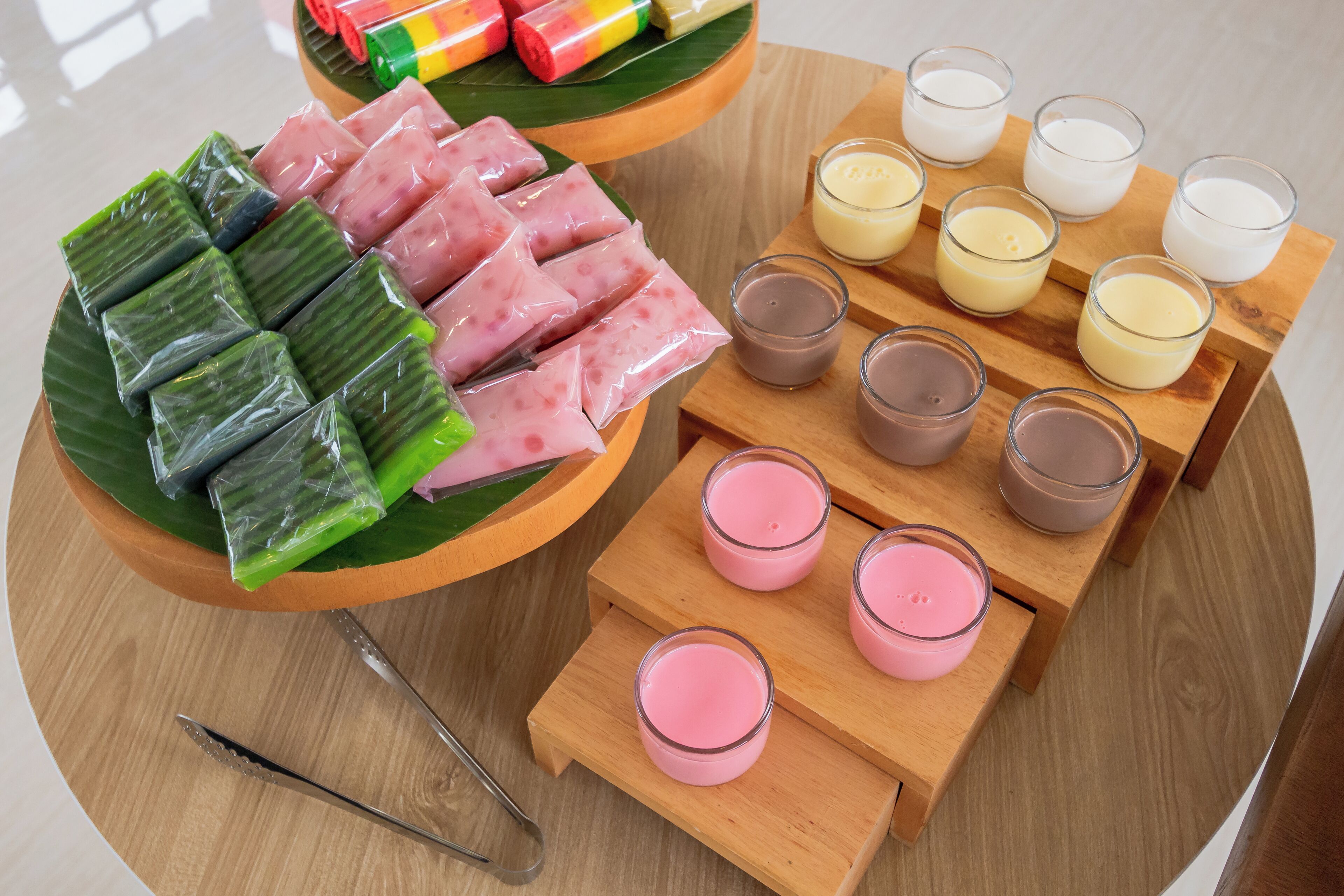 A wooden table with a variety of food items and candles.