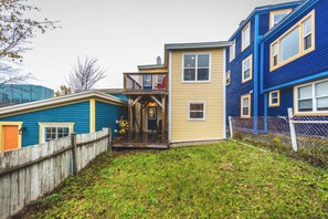 Stylish yellow house featuring a small balcony, lush lawn, and modern design. - Harbour View Rowhome Signal Hill & Downtown (St. John's)