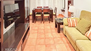 A living room with a TV, dining table, chairs, a sofa, and a lamp. - XILGAR Maracaibo Apartment Central next to the Beach (Sanxenxo)