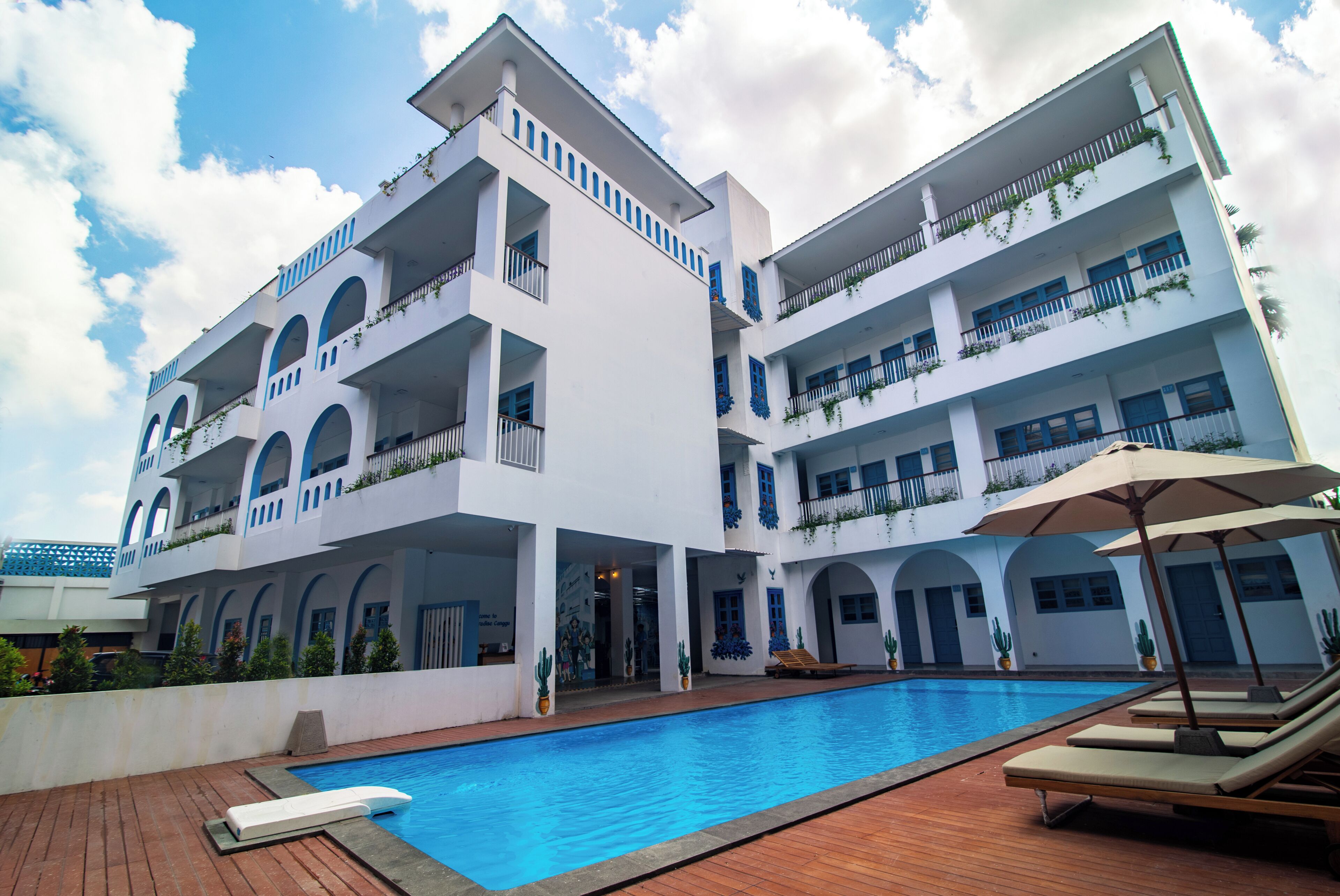 A multi-story hotel with a swimming pool, balconies, and a courtyard.